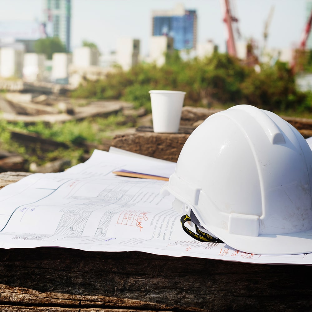 Weißer Helm auf Bauzeichnungen, Baustelle